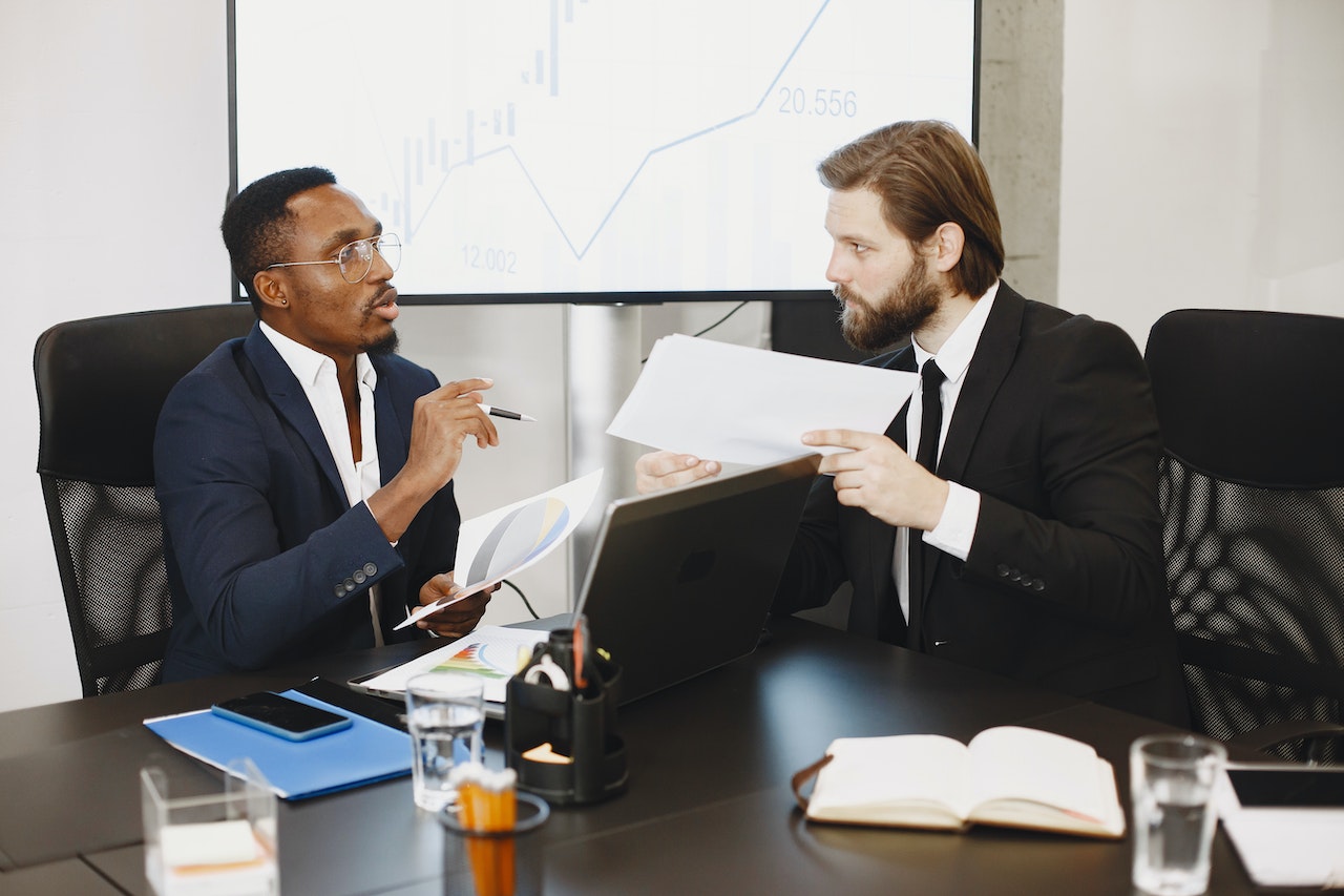 Two Men Comparing Business Data
