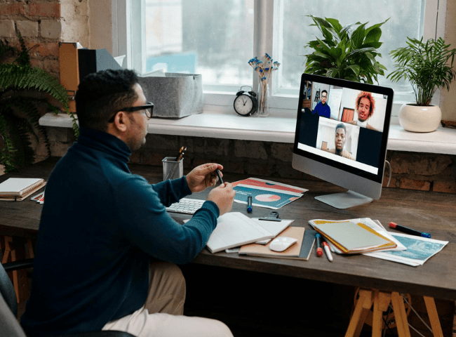 Teacher Video Calling with His Students Using a Computer