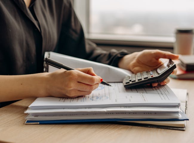 Person in Long Sleeve Shirt Holding a Calculator