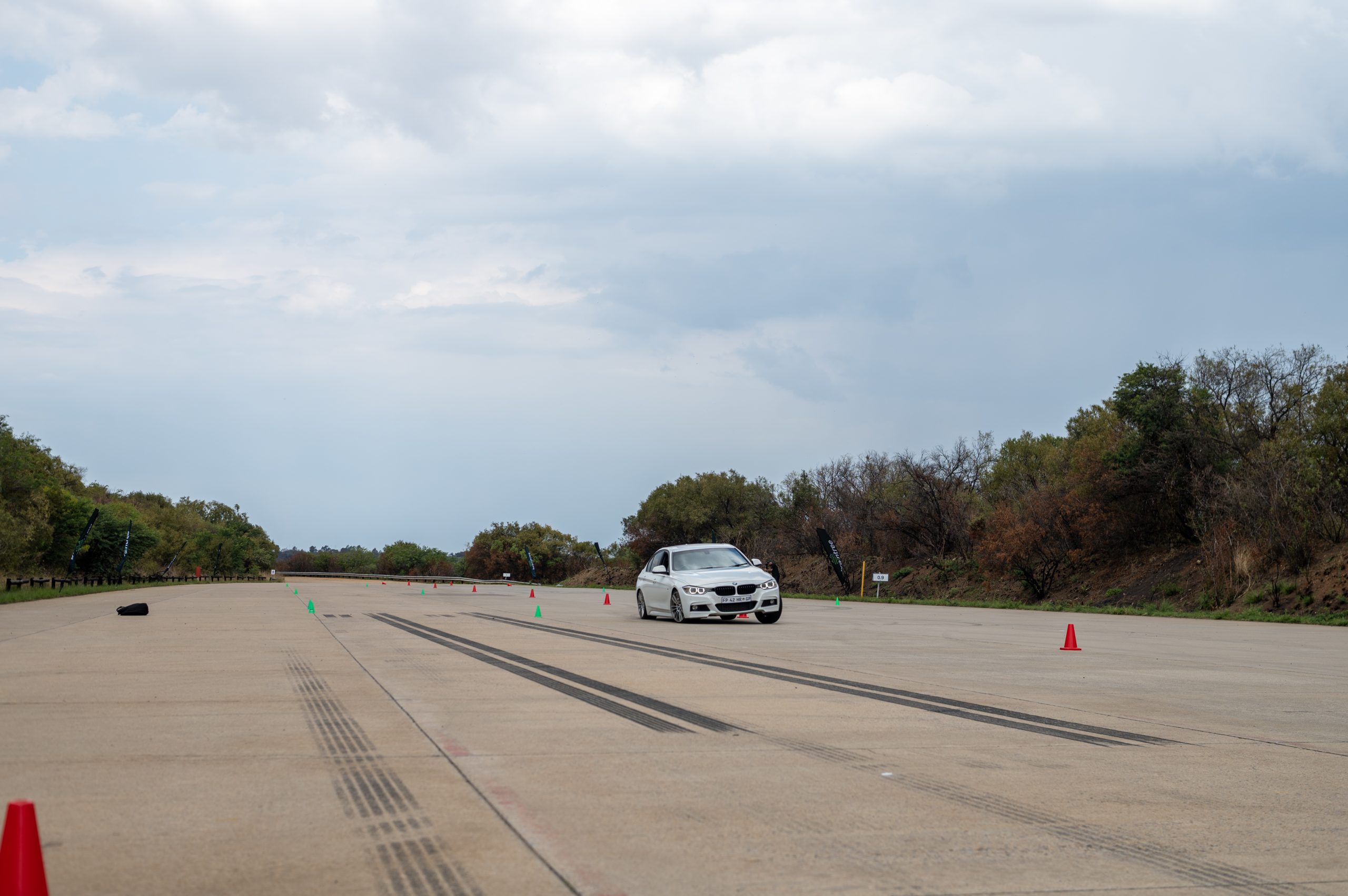 white BMW driving between multiple cones