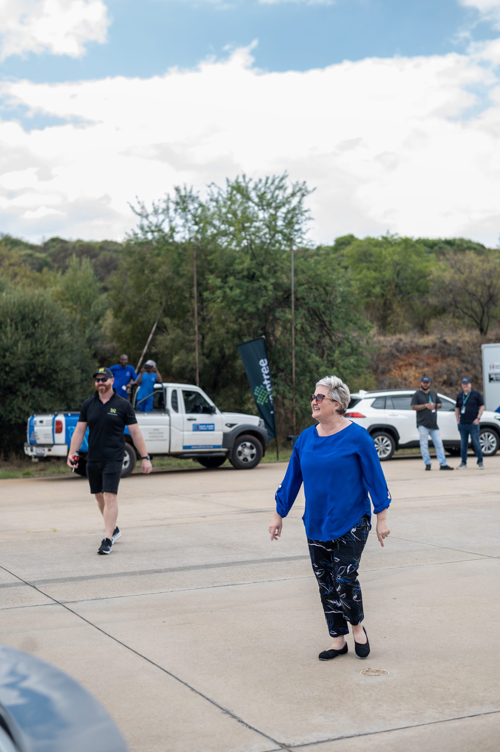 two people walking toward a small supercar