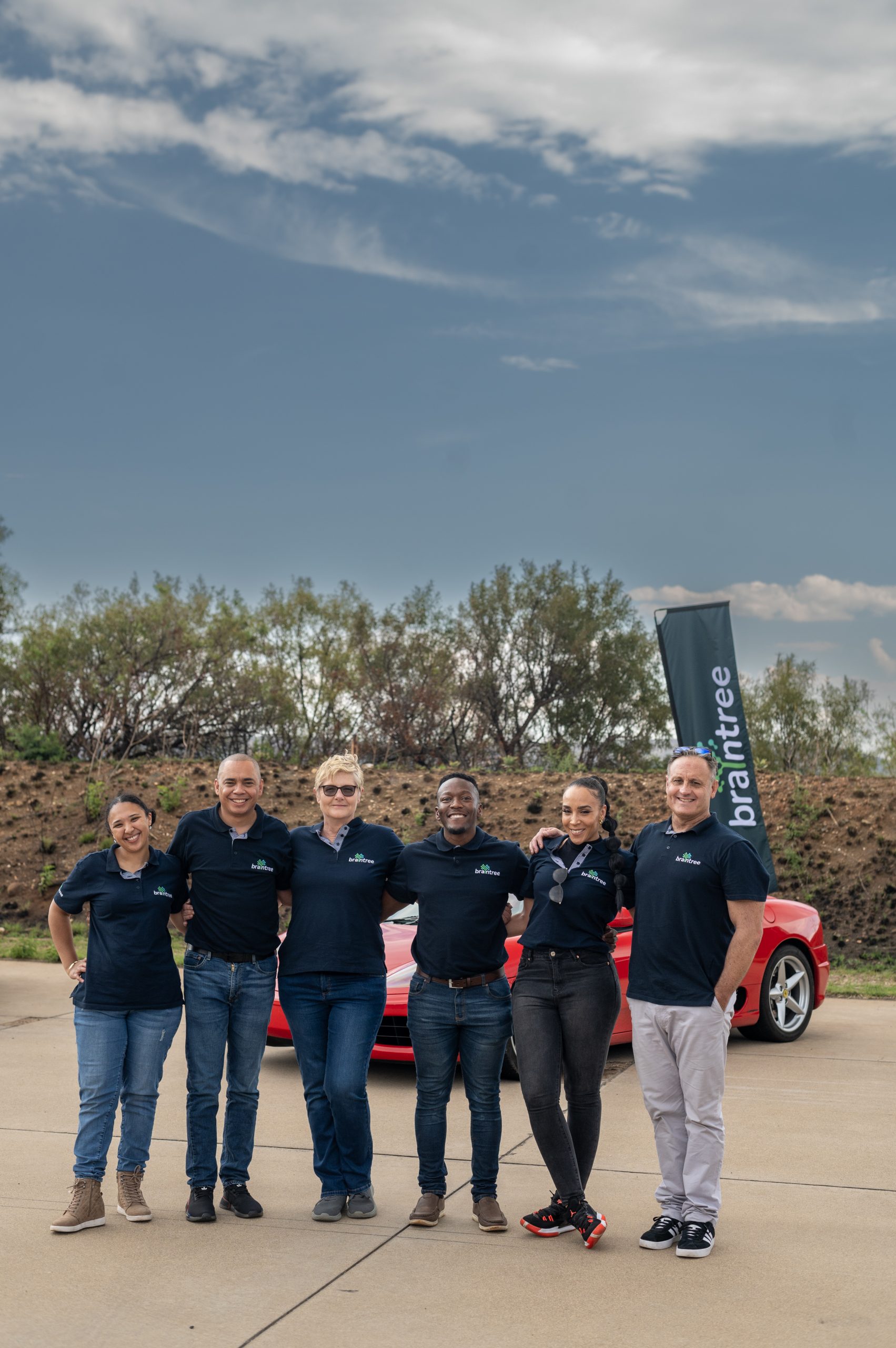 Braintree employees standing in front of supercars