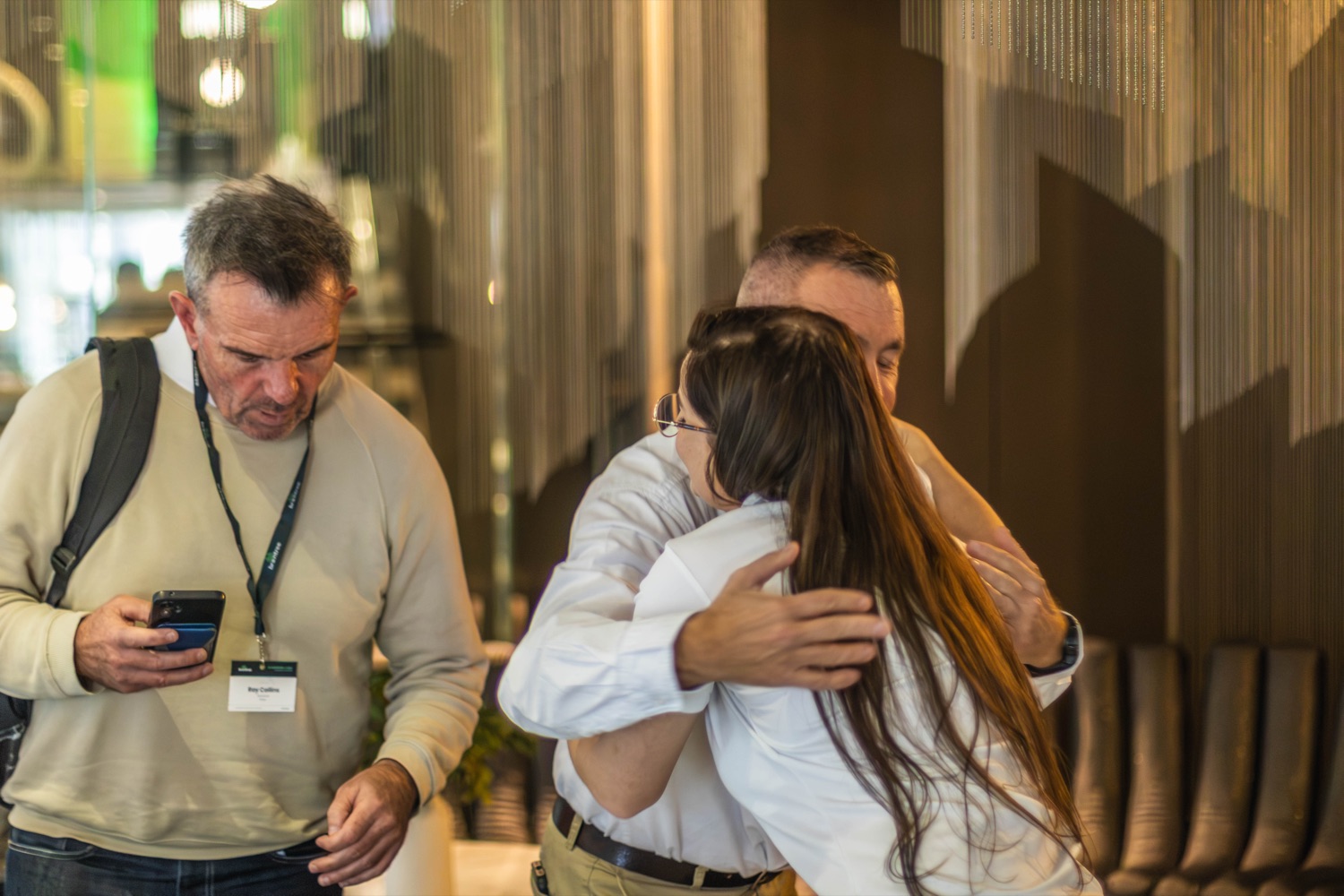 Colleagues share a warm greeting as they reconnect