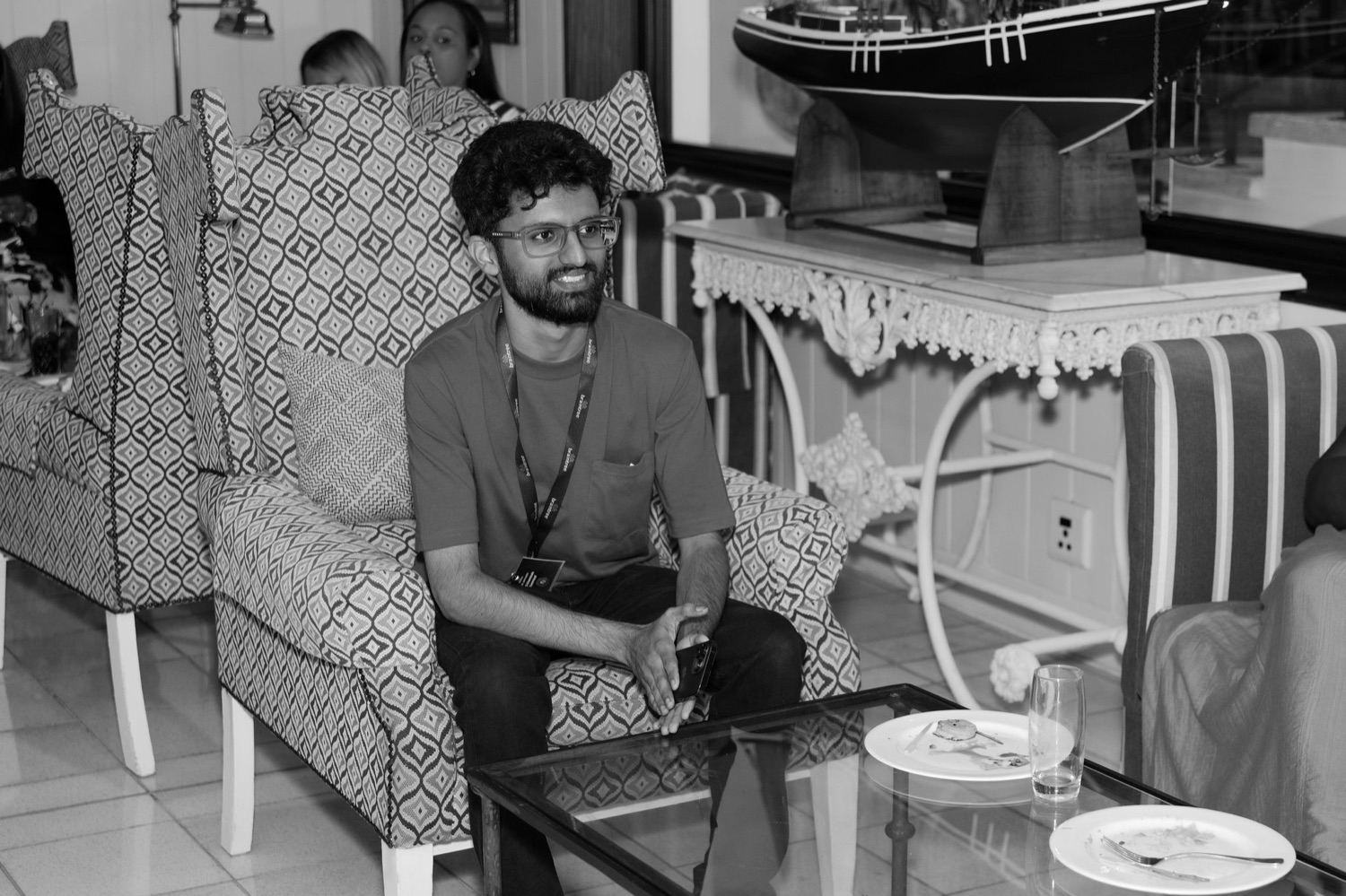 A guest seated in a relaxed lounge setting, black and white