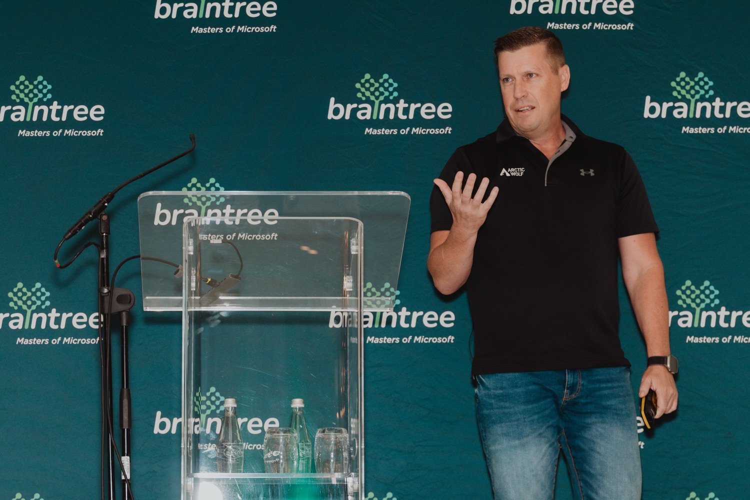 A speaker addressing the room from the podium with Braintree branding behind