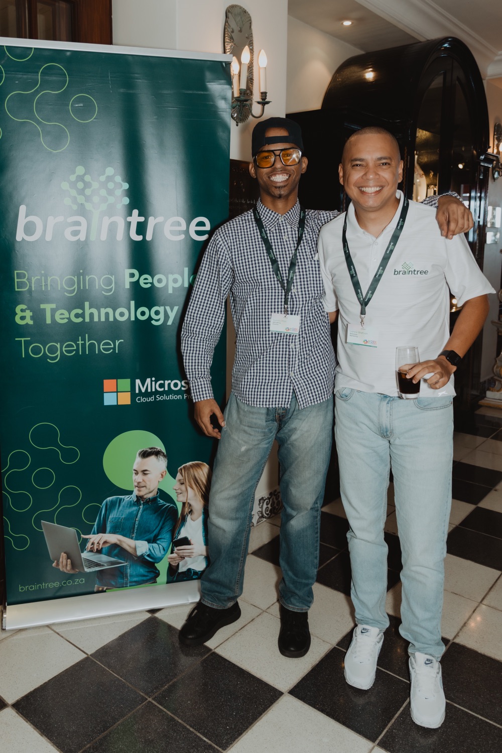 Guests posing beside a branded event banner
