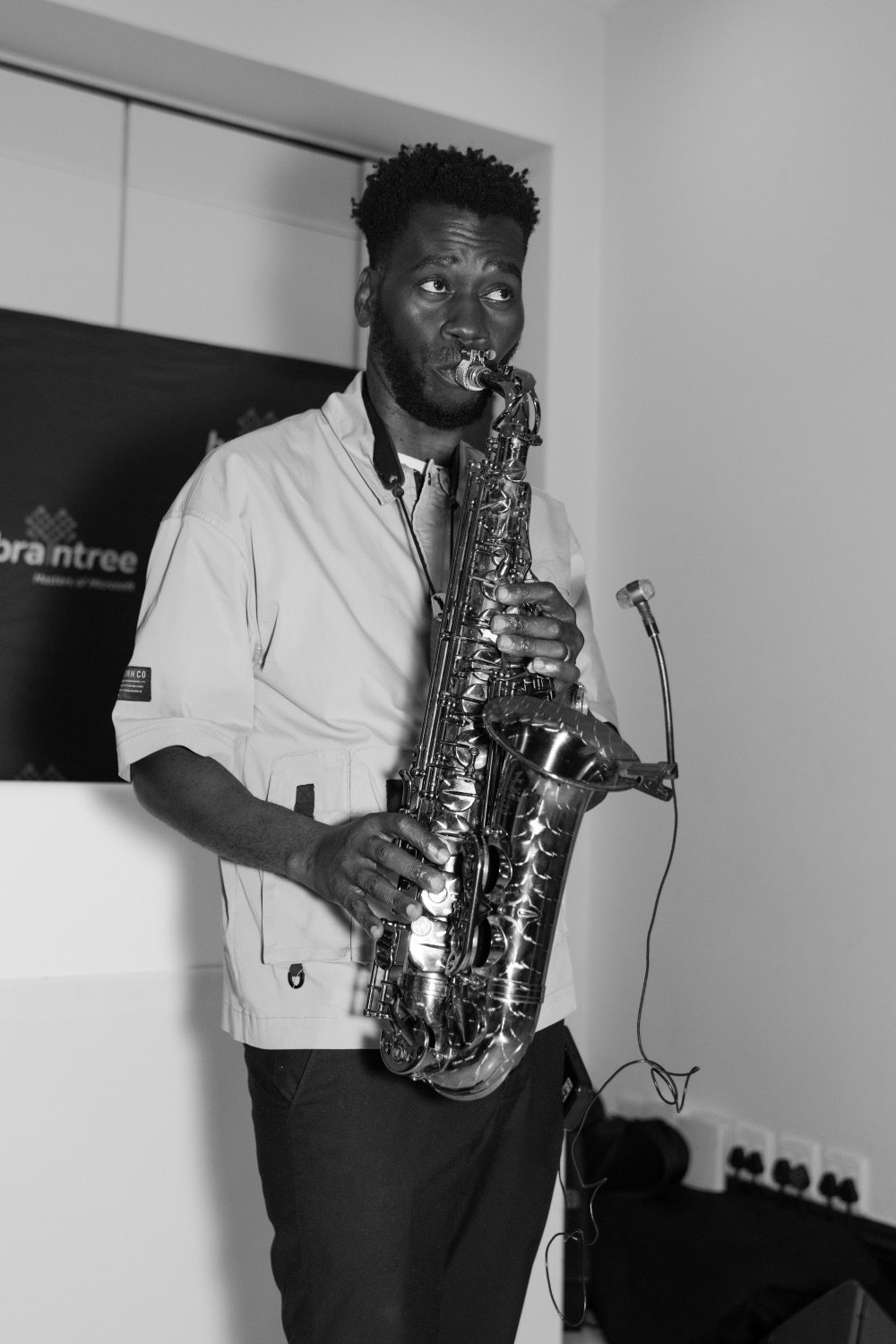 A saxophonist playing beside the Braintree banner during the reception