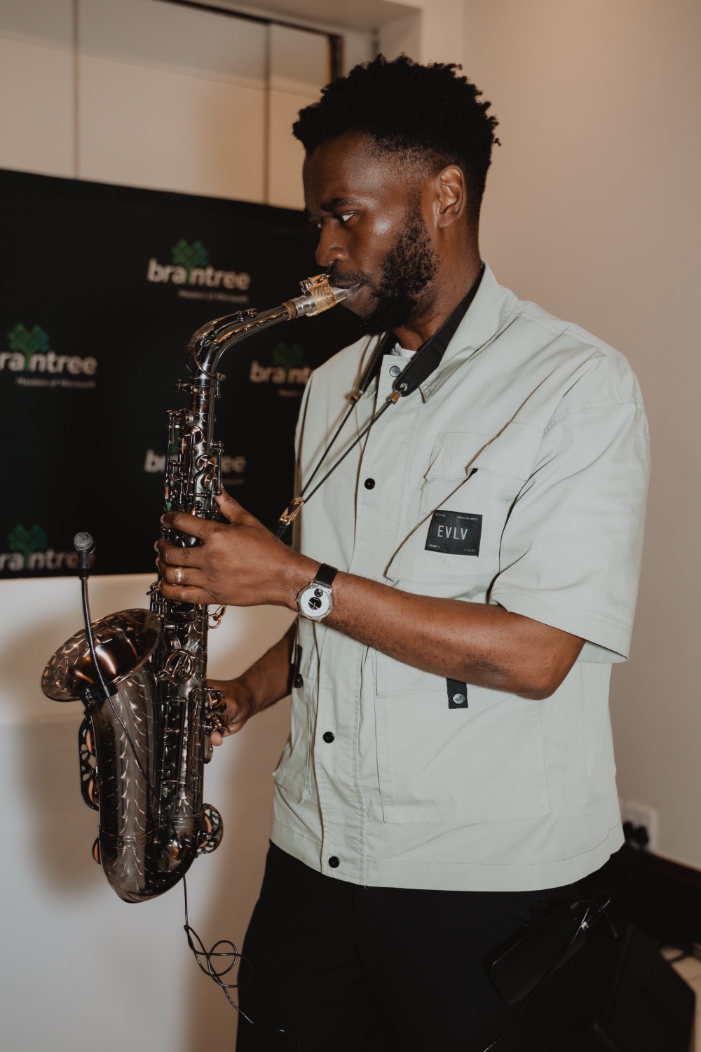 A live saxophonist performing in front of the Braintree branding
