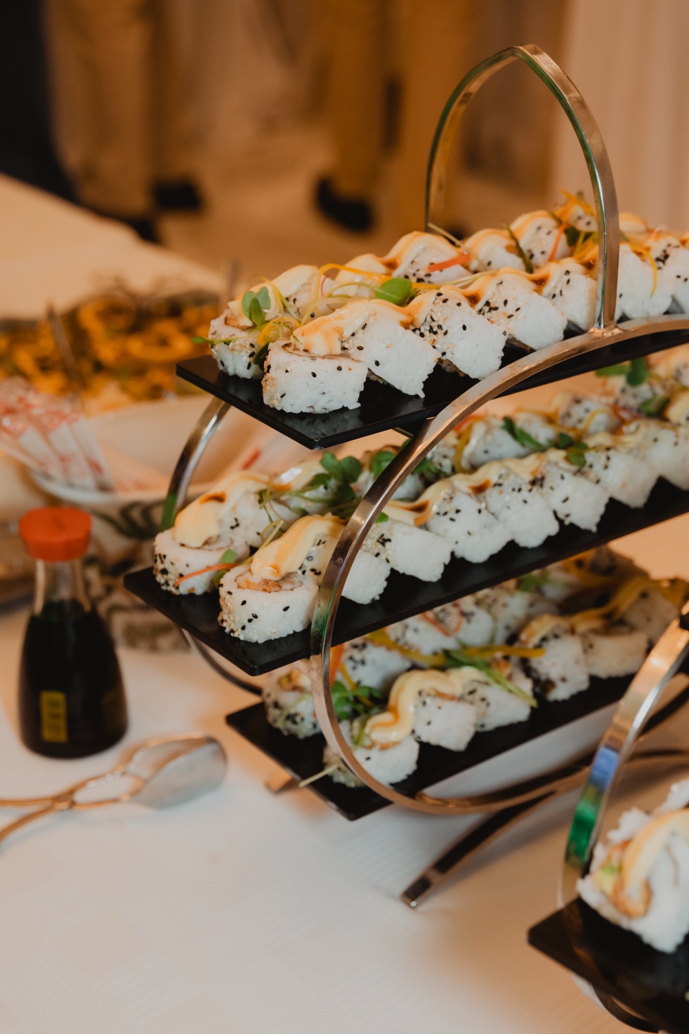 A tiered display of sushi and canapes at the event catering