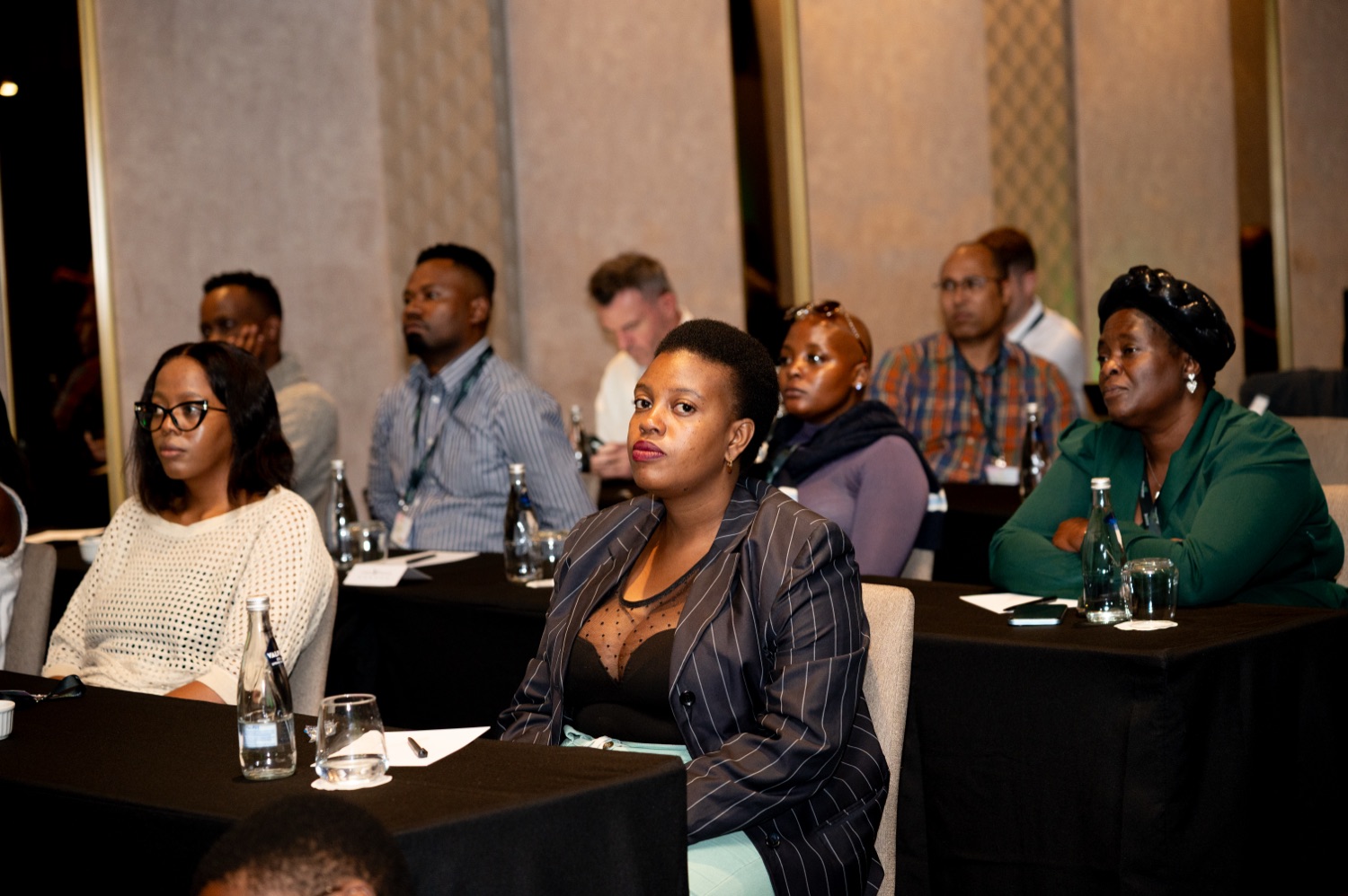 Attendees smiling and engaged during a session