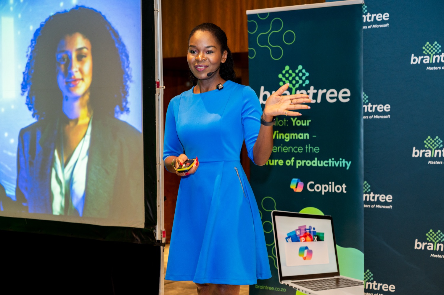 A speaker presenting in front of a Copilot slide and Braintree banner
