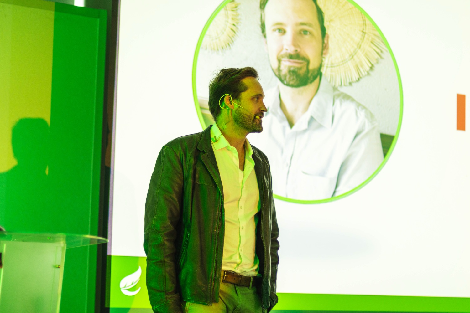 A speaker in conversation beside the projected customer story slide